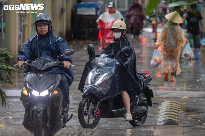 Nhiều người đi xe máy lên vỉa hè trong cơn mưa sáng nay.