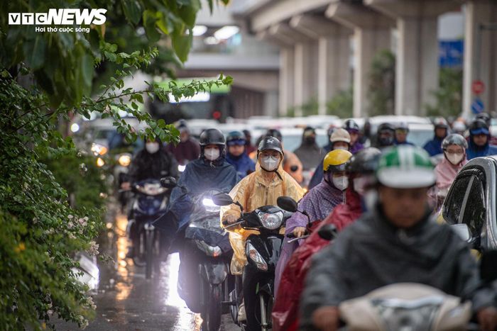 Mưa to đúng giờ người dân đi làm khiến việc di chuyển thêm khó khăn. 