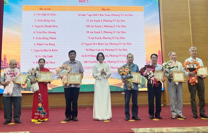 Phó Chủ tịch UBND phường Ô Chợ Dừa Đặng Thị Mai tặng hoa và bằng khen cho các gia đình văn hóa tiêu biểu.