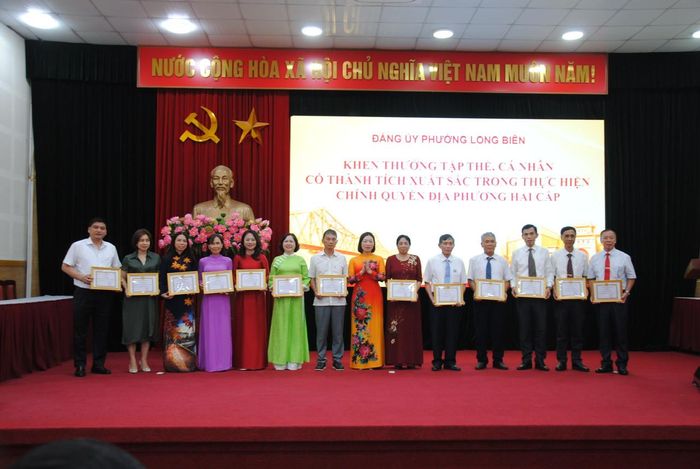 Khen thưởng các tập thể, cá nhân có thành tích xuất sắc trong thực hiện mô hình chính quyền địa phương hai cấp. Ảnh: Thế Dương
