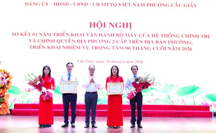 Trung tướng Nguyễn Thanh Tùng, Giám đốc Công an thành phố Hà Nội trao Bằng khen của Ban Thường vụ Thành ùy cho tập thể Đảng ủy phường Cầu Giấy và cá nhân đồng chí Ngô Ngọc Phương, Chủ tịch UBND phường Cầu Giấy vì đã có những thành tích xuất sắc trong 1 năm vận hành mô hình chính quyền địa phương 2 cấp. Ảnh: Vân Nhi