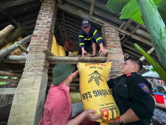 Lực lượng chức năng hỗ trợ người dân vận chuyển đồ lên khu vực cao - (ảnh xã Nguyên Bình).