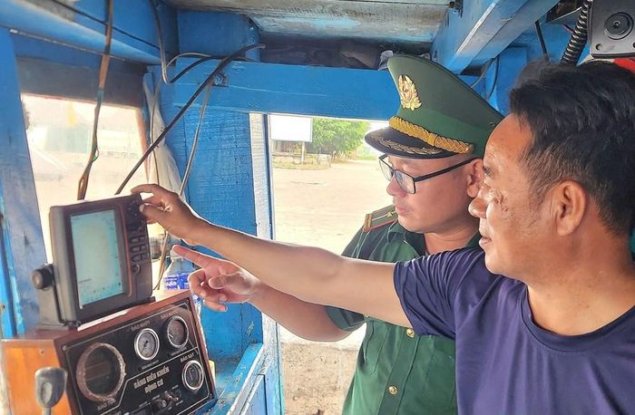 Cán bộ Đồn Biên phòng cửa khẩu cảng Nghi Sơn kiểm tra thiết bị giám sát hành trình, giấy phép khai thác và những quy định liên quan đến chống khai thác IUU. Ảnh: Nguyễn Linh