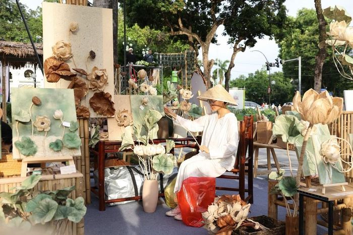 Người thợ thủ công giữa không gian trưng bày các sản phẩm hoa Sen thủ công làm từ sợi Chuối. Ảnh: Tiến Long/TTXVN phát