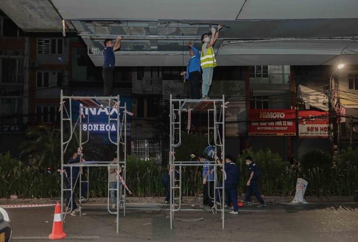 Các công nhân khẩn trương, cẩn thận tháo dỡ những tấm ốp Alu bị vỡ tại khu vực nhà ga Láng trong đêm