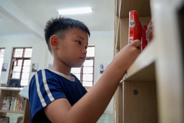 Mỗi buổi chiều, em Hà Trọng Nghĩa (lớp 2) lại đi bộ ra thư viện. Ở nhà, Nghĩa chỉ có vỏn vẹn 5-6 cuốn sách. Thư viện mở ra, em như tìm thấy cả một thế giới khổng lồ với nhân vật Nobita yêu thích. Trong ảnh: Em Trọng Nghĩa đang lựa chọn cuốn sách để đọc trong buổi chiều hôm nay.