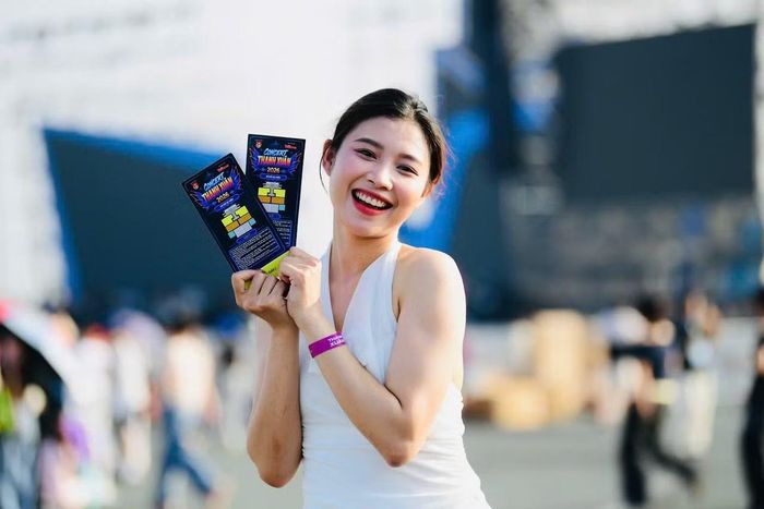 Một fan nữ khoe nụ cười rạng rỡ, thể hiện sự háo hức trước giờ concert khai màn. Đây là sự kiện được chờ đợi từ nhiều tuần qua, ai cũng muốn có mặt từ sớm để hòa mình vào không khí lễ hội quy tụ 20.000 khán giả.