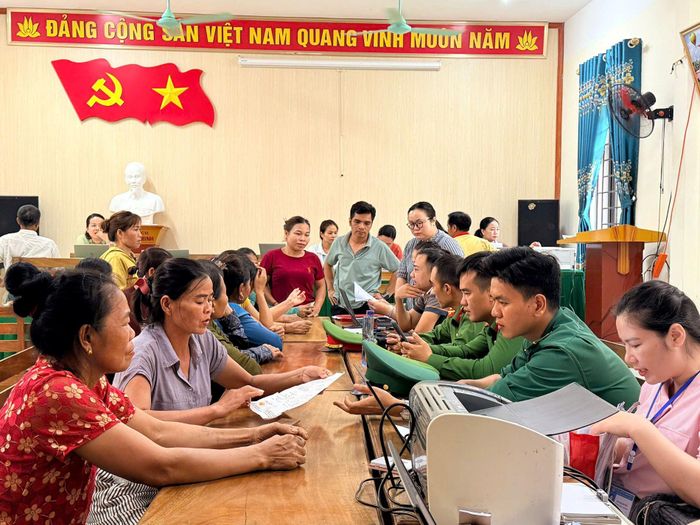 Các lực lượng Công an xã, Bộ đội Biên phòng hỗ trợ người dân cài đặt, sử dụng ứng dụng VNeID, hướng dẫn nộp hồ sơ trực tuyến và thanh toán không dùng tiền mặt - Ảnh: B.D