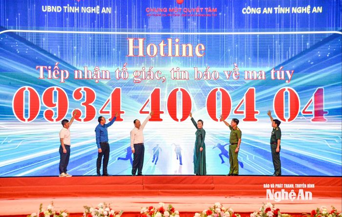 Các đại biểu thực hiện nghi thức kích hoạt đường dây nóng tiếp nhận thông tin tố giác tội phạm, tệ nạn ma túy. Ảnh: Minh Quân