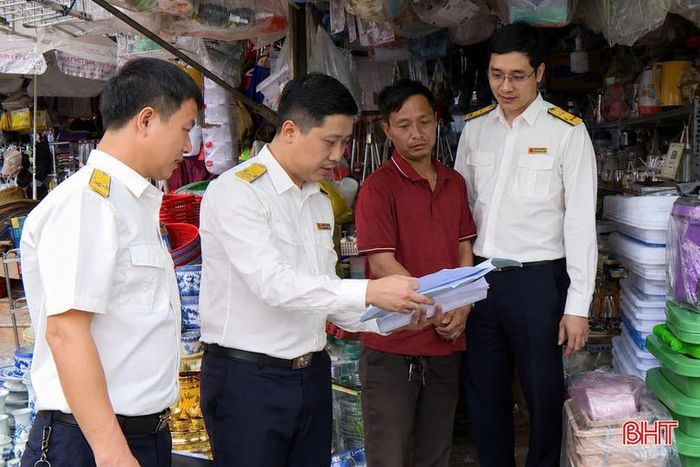 Cán bộ chức năng làm việc với hộ kinh doanh về việc thực hiện nghĩa vụ thuế.
