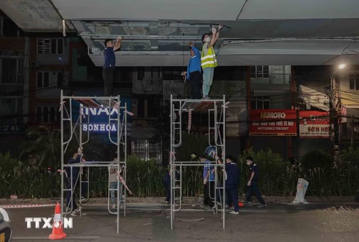 Từ 22h30 ngày 26/6, đội ngũ kỹ sư Hà Nội Metro bắt đầu sửa chữa các tấm ốp Alu bị hỏng do xe quá khổ tại ga Láng, đảm bảo tiến độ và không ảnh hưởng đến giao thông. (Ảnh: Phan Phương/TTXVN)