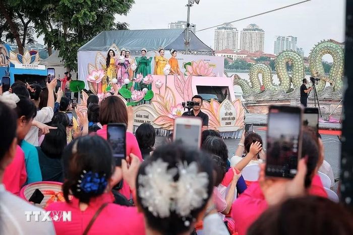 Đoàn diễu hành nghệ thuật “Sắc Sen Tây Hồ – Hà Nội” đi qua tuyến phố ven Hồ Tây với sự tham gia của đông đảo câu lạc bộ, hội đoàn và người dân. (Ảnh: Phạm Tuấn Anh/TTXVN)