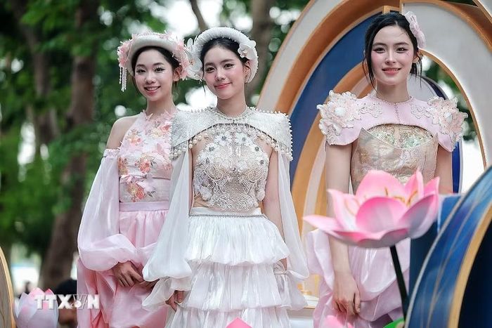 Các người mẫu trong trang phục lấy cảm hứng từ hoa sen trình diễn trên xe hoa, góp phần làm phong phú thêm ngôn ngữ nghệ thuật của chương trình. (Ảnh: Phạm Tuấn Anh/TTXVN)