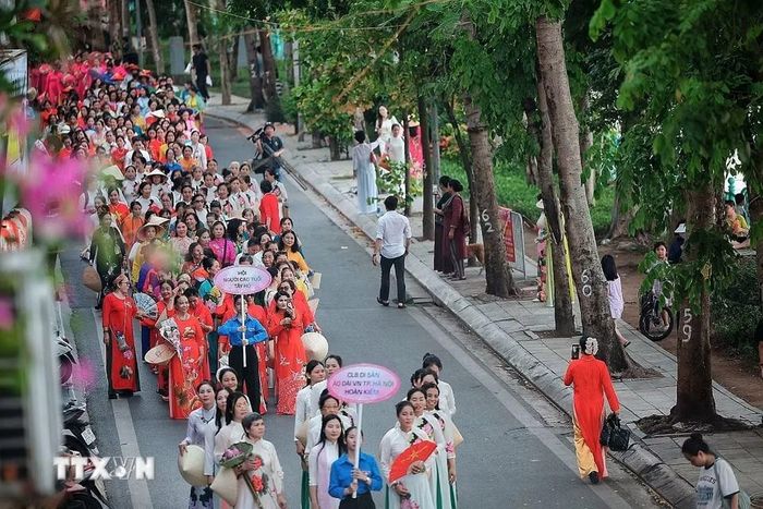 Toàn cảnh đoàn diễu hành nghệ thuật “Sắc Sen Tây Hồ-Hà Nội” đi qua tuyến phố ven Hồ Tây với sự tham gia của đông đảo câu lạc bộ, hội đoàn và người dân. (Ảnh: Phạm Tuấn Anh/TTXVN)