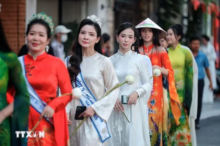 Những tà áo dài rực rỡ sắc sen nối dài trong đoàn diễu hành nghệ thuật “Sắc Sen Tây Hồ - Hà Nội." (Ảnh: Phạm Tuấn Anh/TTXVN)