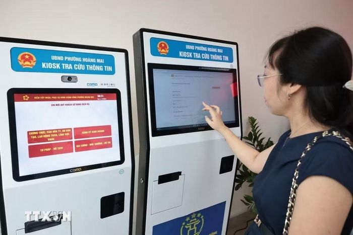 Người dân lấy số làm thủ tục hành chính tại bộ phận phục vụ hành chính công của Ủy ban Nhân dân phường Hoàng Mai, Hà Nội. (Ảnh: Trần Việt/TTXVN)