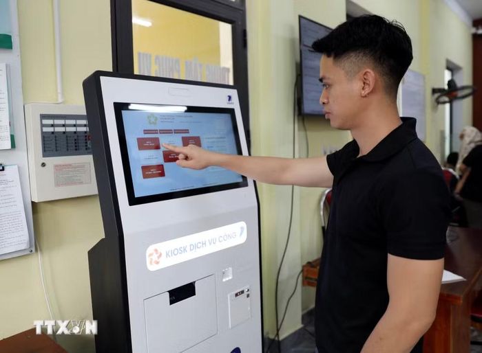 Người dân phường Mỹ Lâm (tỉnh Tuyên Quang) đăng ký thủ tục hành chính qua kiốt dịch vụ công. (Ảnh: Quang Cường/TTXVN)