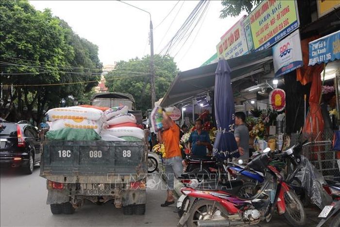 Tiểu thương ở Chợ Xanh di dời hàng hóa ra khỏi vùng có nguy cơ ngập lụt. Ảnh: Chu Hiệu/TTXVN