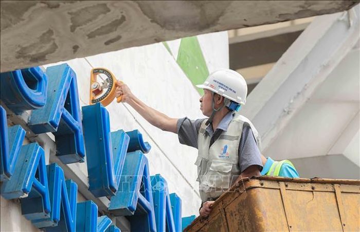 Các kỹ sư sử dụng búa bật nảy chuyên dụng để kiểm tra, đánh giá chính xác cường độ và chất lượng lớp vữa trát tại các nhà ga. Ảnh: Phan Phương/TTXVN