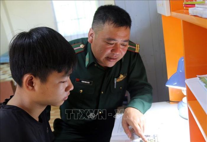 Cán bộ Đồn Biên phòng Đắk Dang, tỉnh Lâm Đồng hướng dẫn “Con nuôi đồn Biên phòng” học bài. Ảnh: TTXVN phát