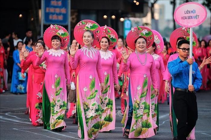 Đoàn Liên hội Hoa Sen Việt nổi bật với áo dài hồng, nón sen và họa tiết hoa sen, mang đến sắc màu đặc trưng cho lễ hội bên Hồ Tây. Ảnh: Phạm Tuấn Anh/TTXVN