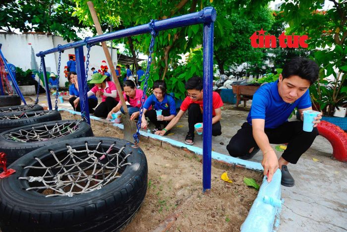 Các đoàn viên, thanh niên sơn sửa, lắp đặt góc vui chơi cho trẻ em ở khu phố 9, phường Bình Thạnh.