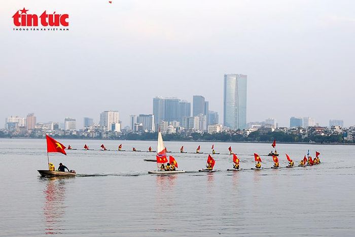 Đoàn thuyền mang cờ Tổ quốc diễu hành trên mặt nước Hồ Tây, tạo không khí sôi động cho lễ hội.