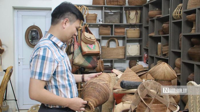 Du khách chăm chú quan sát sản phẩm tại xưởng của nghệ nhân Hoàng Văn Hạnh.