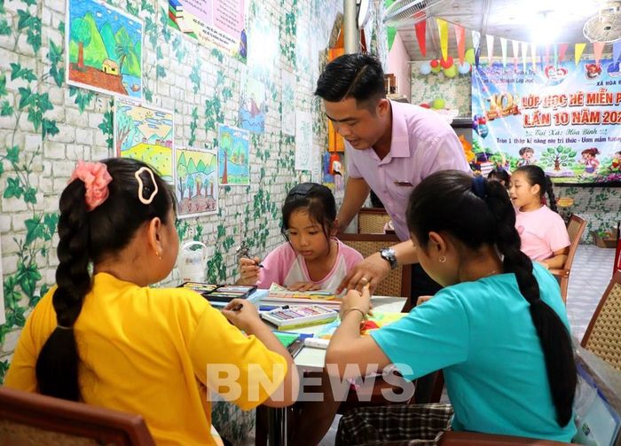 Thầy Nguyễn Khánh hướng dẫn các em học sinh ở lớp học hè. Ảnh: Lê Thúy Hằng – TTXVN