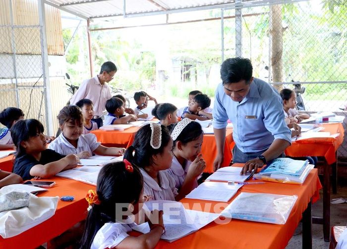 Thầy Nguyễn Khánh đến thăm và tổ chức hoạt động trải nghiệm tại lớp học hè dành cho các em học sinh vùng đồng bào Khmer. Ảnh: Lê Thúy Hằng – TTXVN