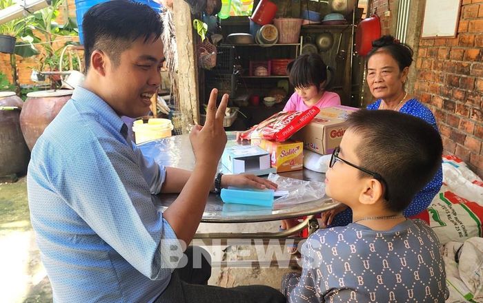 Thầy Nguyễn Khánh hỗ trợ em Minh Thiện kính mắt để em có thể thấy ánh sáng, tự học tập, sinh hoạt và làm điểm tựa cho chị gái. Ảnh: Lê Thúy Hằng – TTXVN