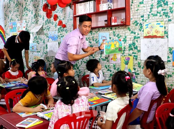 Thầy Nguyễn Khánh hướng dẫn các em học sinh ở lớp học hè. Ảnh: Lê Thúy Hằng – TTXVN