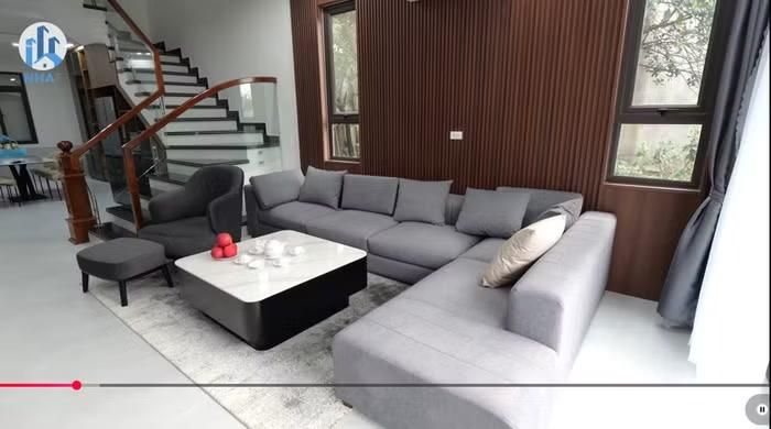 Phòng khách được thiết kế rộng rãi với bộ sofa lớn và chiếc tivi màn hình lớn, tạo nên không gian lý tưởng để tiếp đón bạn bè và người thân