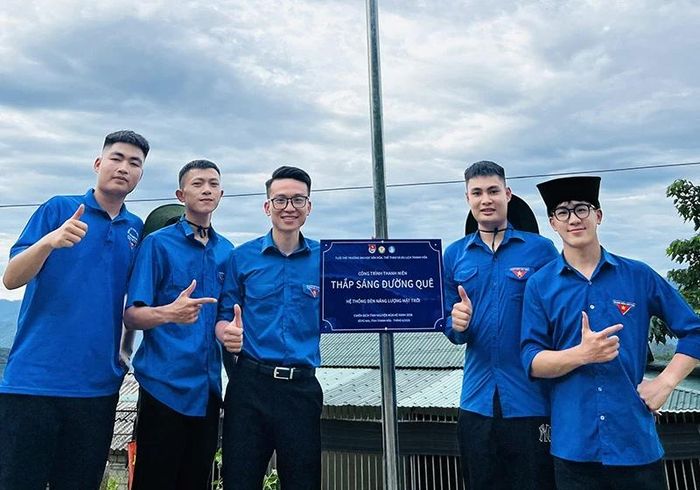 Sinh viên Lê Văn Dự (ngoài cùng, bên trái) bên công trình “Thắp sáng đường quê”.