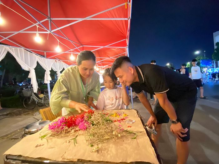  Du khách trải nghiệm làm giấy dó trên tuyến phố đêm phường Võ Cường. 