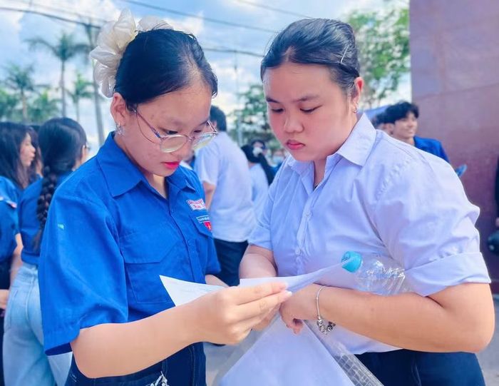  Tình nguyện viên hỗ trợ thí sinh giải đề tiếng Anh sau khi kết thúc giờ thi tại điểm thi Trường THPT Trưng Vương (phường Quy Nhơn). Ảnh: Trần Dung 