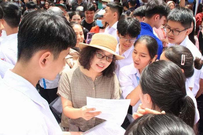  Các thí sinh được cô giáo phân tích đề sau khi kết thúc bài thi Ngữ văn. Ảnh: Hoàng Hoài 