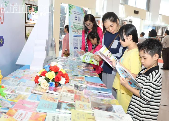 Các em nhỏ và người dân tìm hiểu, đọc sách tại ngày hội.