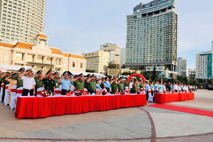 Các đại biểu thực hiện nghi thức chào cờ trong lễ mít tinh.