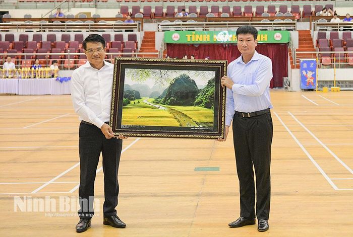 Đồng chí Trần Huy Tuấn, Ủy viên Trung ương Đảng, Bí thư Tỉnh ủy trao tặng bức tranh phong cảnh Ninh Bình cho đồng chí Nguyễn Huy Tiến, Ủy viên Trung ương Đảng, Viện trưởng Viện Kiểm sát Nhân dân tối cao.