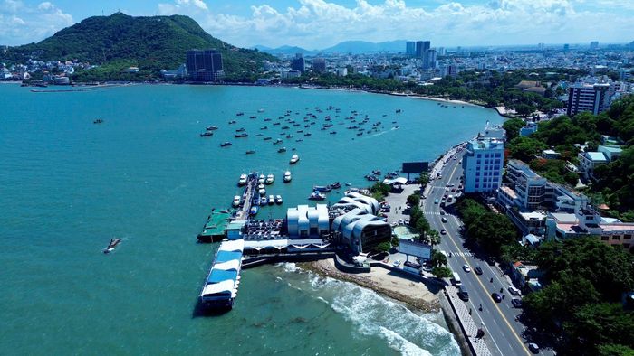 Nhìn từ trên cao, toàn bộ tuyến đường hiện lên mềm mại theo đường cong của vịnh biển. Mặt nước xanh ngắt điểm xuyết hàng chục tàu thuyền neo đậu, phía xa là những dãy nhà, khách sạn và công trình đặc trưng của Vũng Tàu, tạo nên khung cảnh vừa thơ mộng, vừa sôi động. Đây cũng là một trong những đoạn đường được chờ đợi nhất trên hành trình chinh phục Giải chạy Báo Xây dựng 2026.