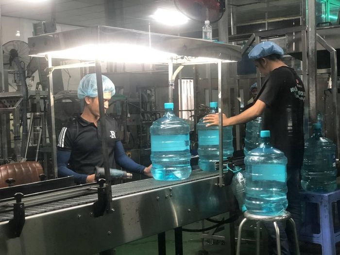 Công nhân Công ty TNHH Fujiwa Việt Nam bên các dây chuyền sản xuất nước khoáng của nhà máy.
