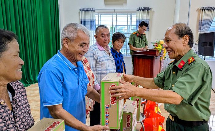 Đại tá Phan Quang Điểm, Nguyên Phó Giám đốc Công an tỉnh, Phó Chủ tịch thường trực Hội Cựu Công an nhân dân tỉnh An Giang trao quà cho các gia đình. Ảnh: Nghiêm Túc