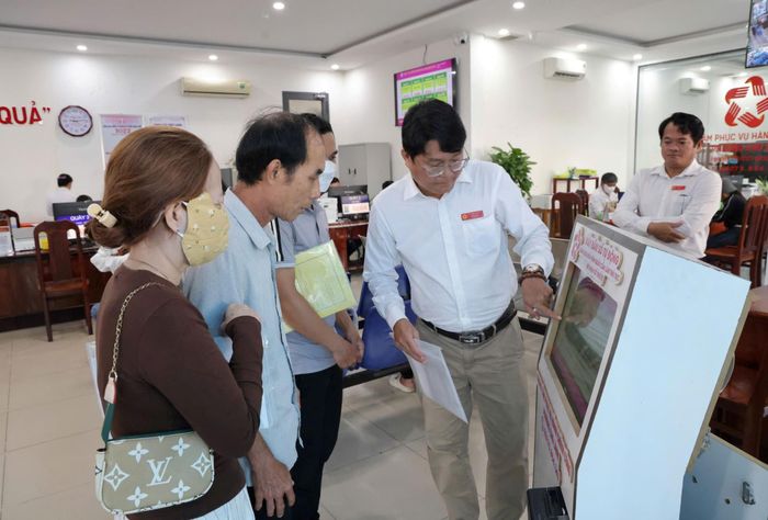 Phó Giám đốc Trung tâm phục vụ hành chính công phường Cao Lãnh hướng dẫn người dân lấy số thứ tự tại Kios