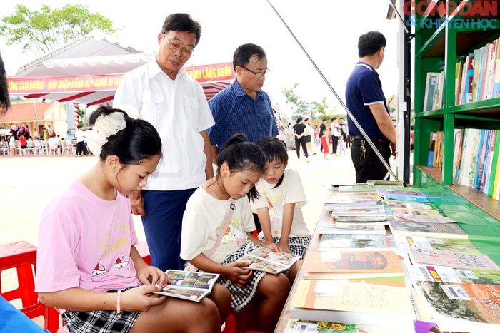 Các em học sinh say mê bên những cuốn sách ngay tại đình Làng Nhớn. Ảnh: Quốc Hồng