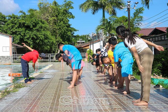 Các học viên được hướng dẫn khởi động trước khi xuống nước, bảo đảm an toàn trong quá trình tập luyện.