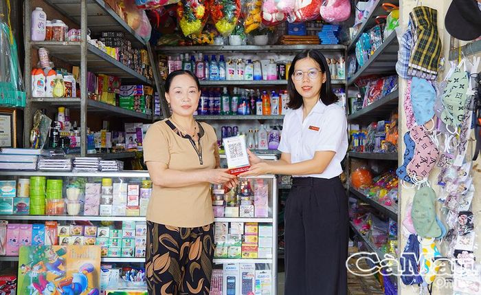 Nhân viên Agribank U Minh trao tài khoản và mã QR tận tay tiểu thương khu vực chợ xã.