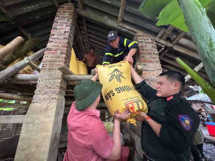 Lực lượng chức năng hỗ trợ người dân dọn dẹp, vận chuyển đồ đạc sau lũ. (Ảnh: Công an tỉnh Cao Bằng)