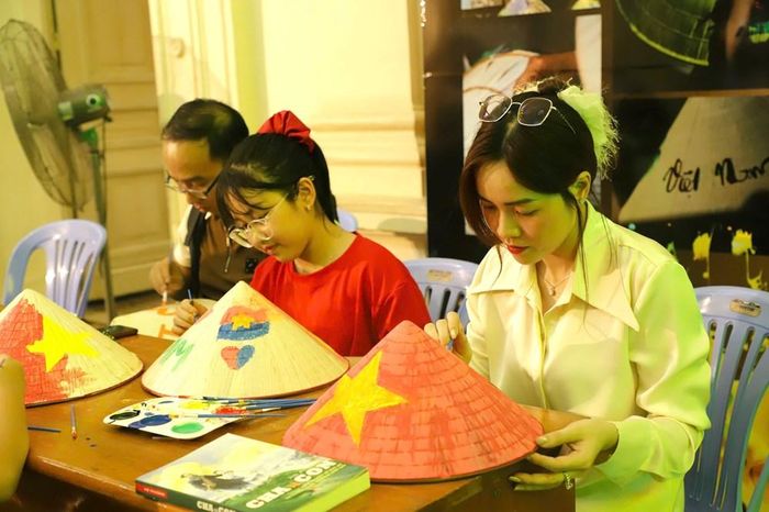 Nhiều gia đình đến trải nghiệm vẽ trên nón lá