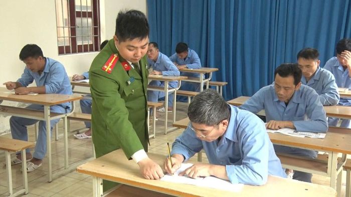 Cán bộ công an trực tiếp hướng dẫn học viên tập đọc, tập viết từng con chữ trong lớp học xóa mù chữ. Ảnh: Công an Thanh Hóa